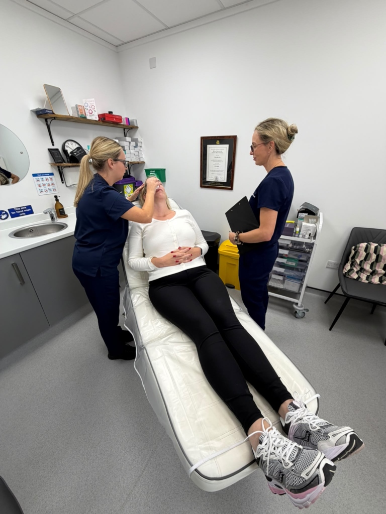 Trainer supervising a delegate assessing a live model in the treatment room